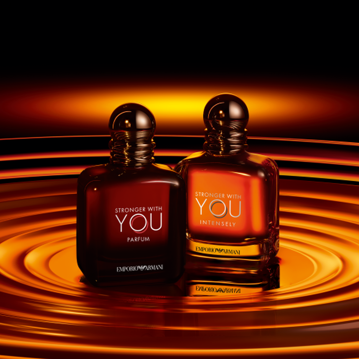 Flacons Emporio Armani Stronger With You Parfum et Stronger With You Intensely, tons ambres chauds sur fond de vagues dorees tourbillonnantes