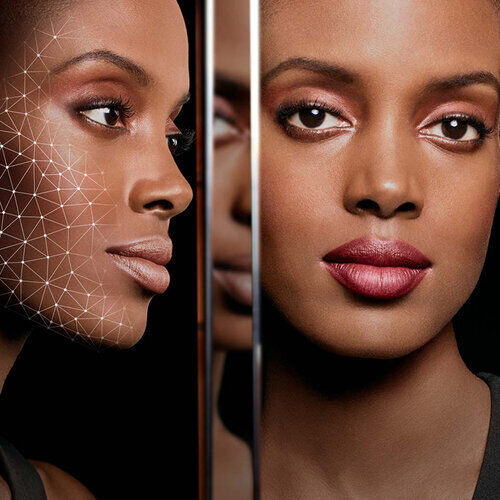 A split image showing two profiles of a woman; one side features a digital wireframe overlay, while the other displays her natural beauty with makeup. The background is dark, highlighting the contrast between the two sides.