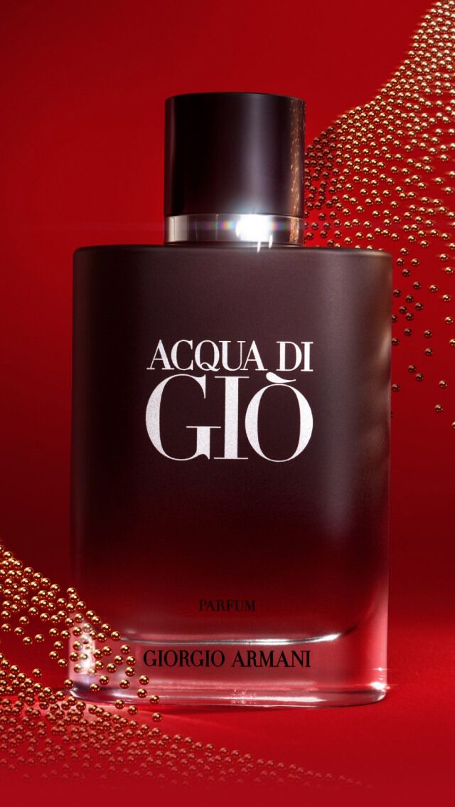 Flacon de parfum Acqua di Gio de Giorgio Armani sur un fond rouge, avec des motifs de points lumineux en arriere-plan.