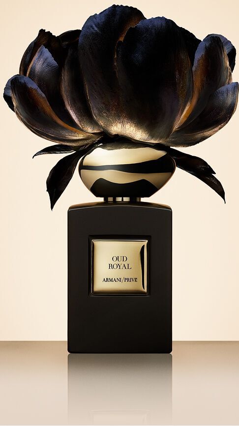 Armani/Prive Oud Royal: a deep black bottle crowned with a dark flower featuring gold reflections, capturing the royal essence of Oud wood and the sacred refinement of Oriental palaces.