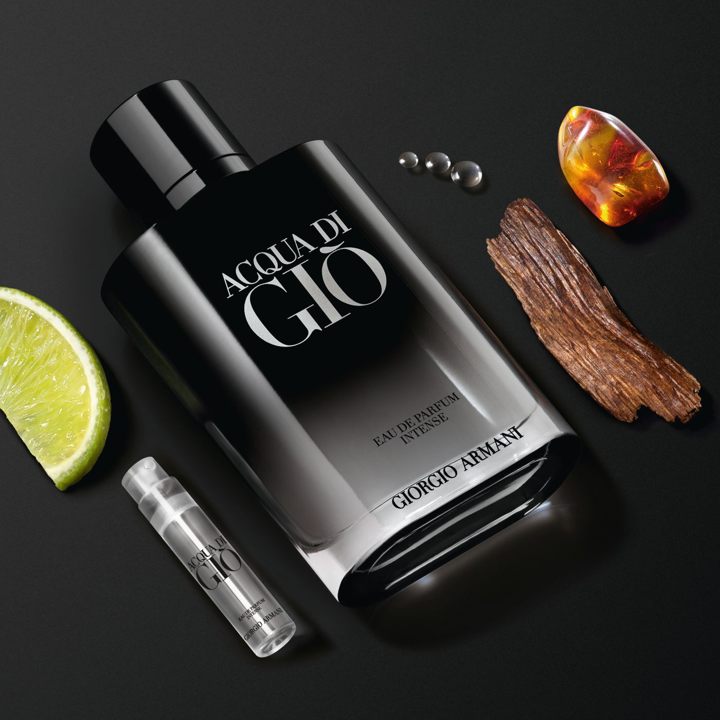 Flacon Acqua di Gio Eau de Parfum Intense avec citron vert, bois, ambre et echantillon sur fond noir.