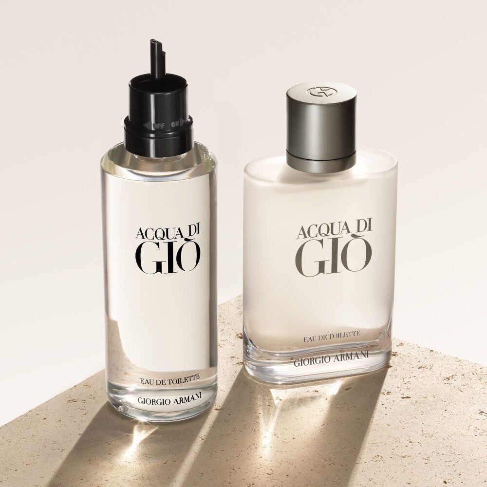 Deux flacons d'eau de toilette Acqua di Gio, la recharge a gauche, sont presentes sur un fond texture beige.