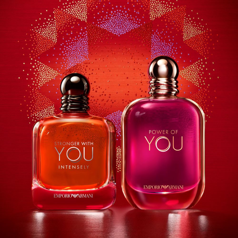 Deux parfums Emporio Armani, Stronger With You Intensely et Power of You, sur un fond festif rouge.​