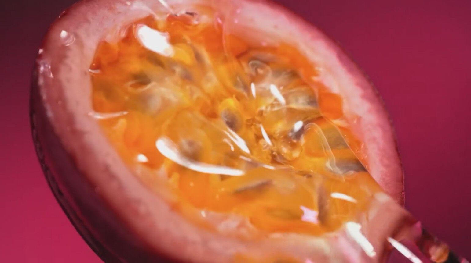 Juicy visuals of Maracuja (passion fruit), frangipani, and vanilla swirling in the radiant ruby liquid, ending with the ARMANI POWER OF YOU bottle framed by a glowing, flickering eagle of light.