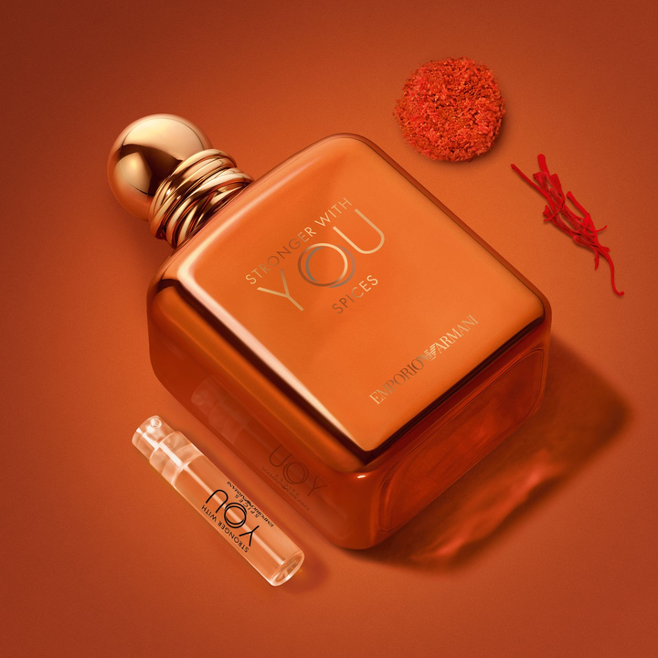 L'allure magnetique du parfum Stronger With You Spices et son flacon decouverte, entoures de safran et d'accords epices. Un visuel vibrant capturant l'essence chaleureuse et solaire de cette fragrance masculine d'exception et de luxe.