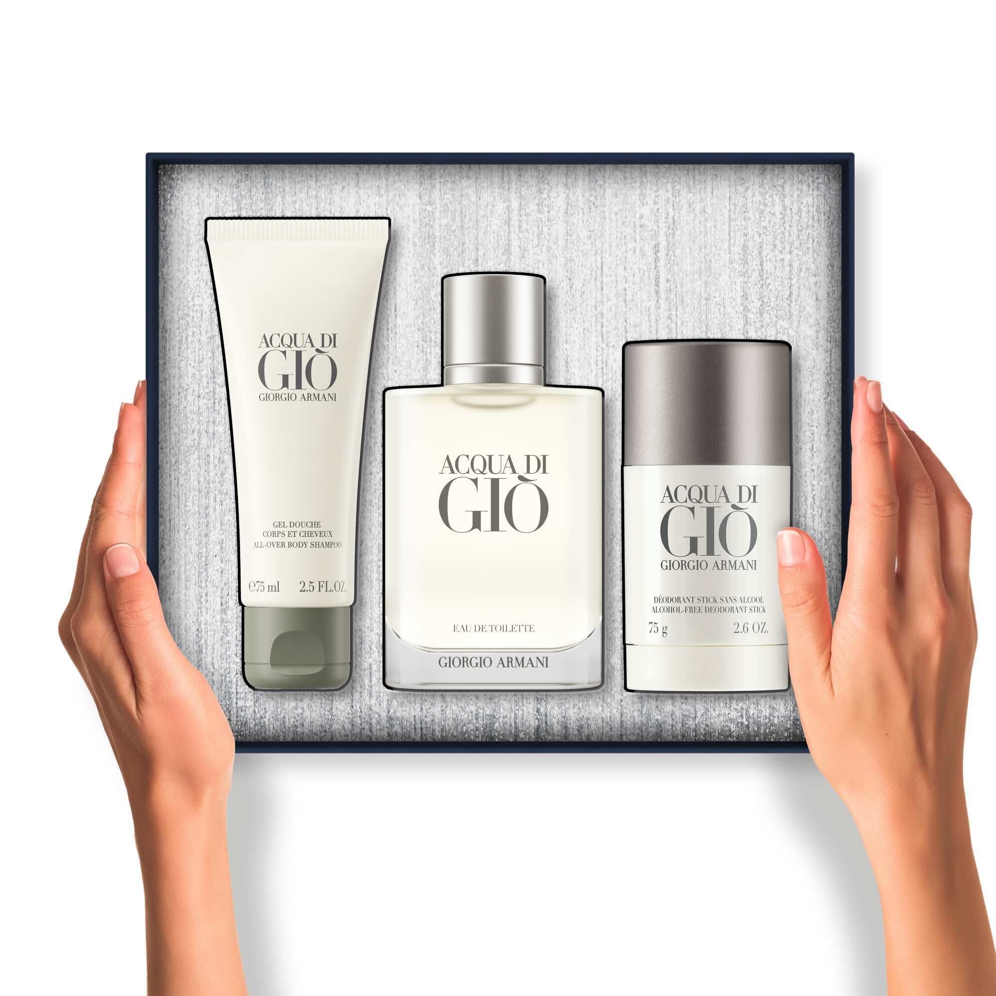 Hands holding an open gift box containing Acqua di Gio Eau de Toilette 100ml, 75 ml showel gel and a 75 ml deodorant.
