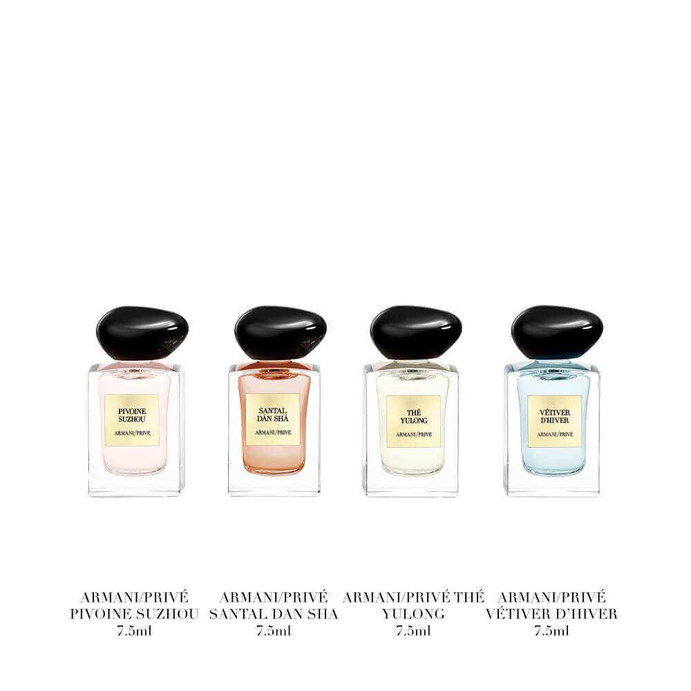 Armani Prive Les Eaux Holiday gift set on white background: open gold box revealing four miniature eau de parfum bottles displayed inside, with additional bottles placed in front.