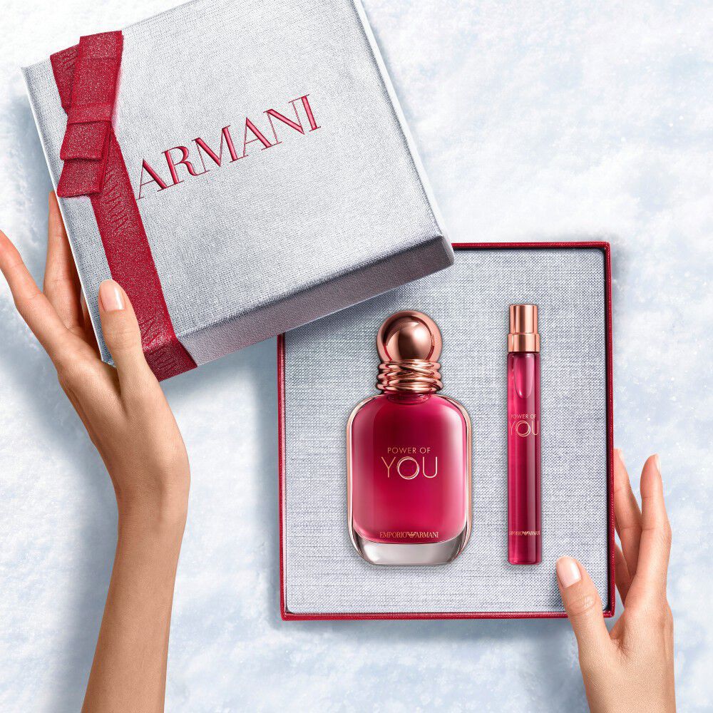 Hands unveiling a red-ribboned white Armani gift box with Power of You Eau de Parfum 30ml and 10ml — a bold, feminine fragrance gift set for women.