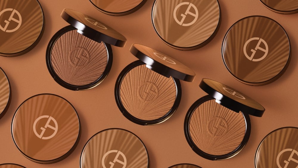 Trois poudres bronzantes Giorgio Armani sur un fond uni, mettant en valeur des teintes chaudes de bronzage.