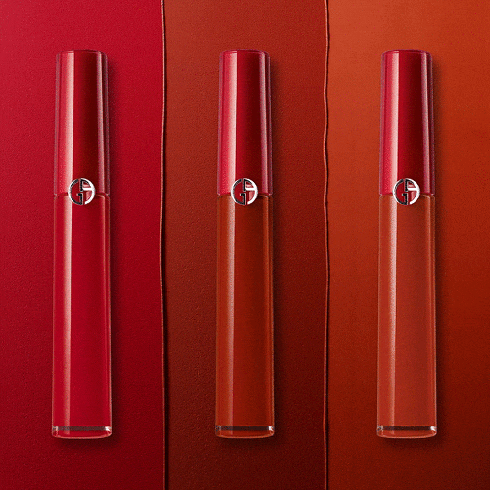 Trois brillants à lèvres de la marque Armani, présentés sur un fond dégradé de rouges.
