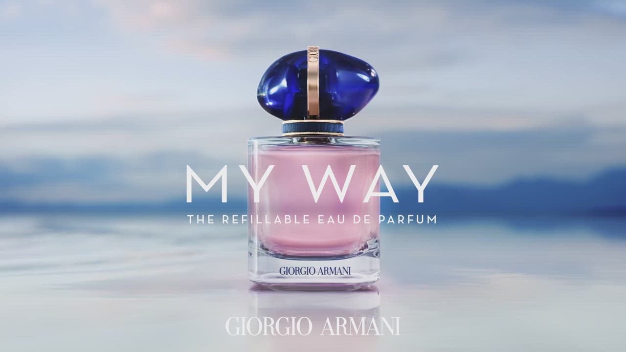 A bottle of Giorgio Armani's 'My Way' refillable Eau de Parfum, featuring a striking blue cap against a serene backdrop.