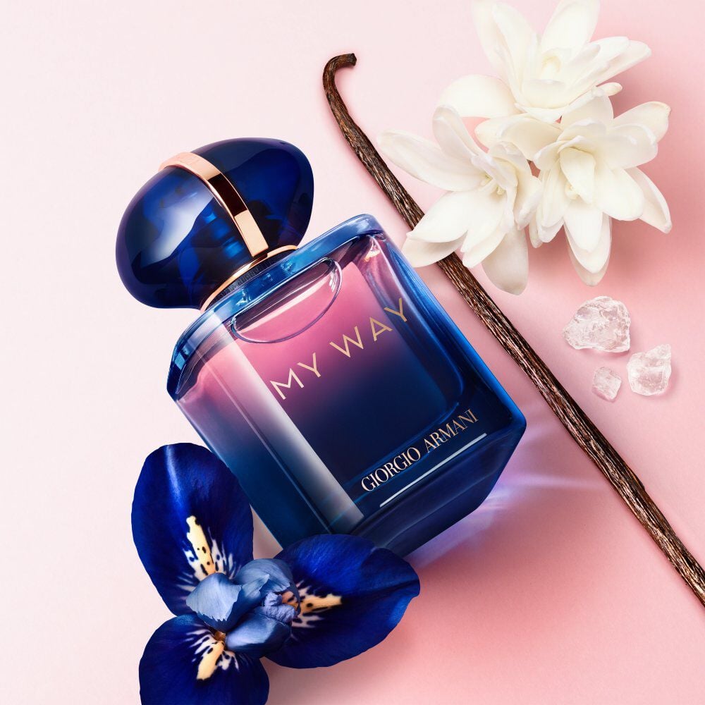Flacon de parfum 'My Way' de Giorgio Armani, entouré d'une fleur d'iris, d'une tige de vanille et de cristaux.